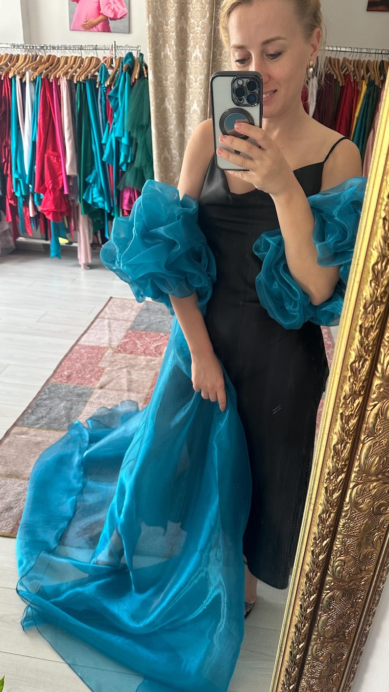 Ριχτό πέπλο με μανίκια στην ουρά. Διατίθεται σε όλα τα χρώματα