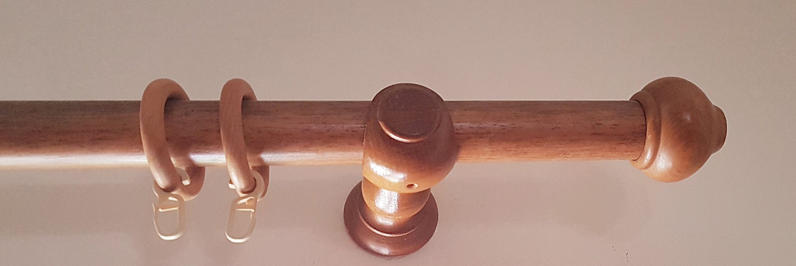 Κουρτινόβεργα ξύλινη με τα διακοσμητικά τελειώματα, τους κρίκους, τα στηρίγματα και τα άγγιστρα.